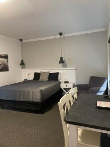 a bedroom with a bed and a table and a couch at Noah's Mid City Motor Inn Muswellbrook in Muswellbrook