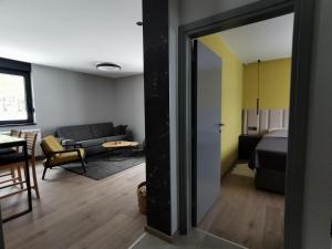 Habitación con cama y sala de estar con sofá. en Vila Nordika Tornik en Tornik