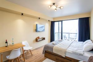 una camera da letto con un letto, una scrivania e una finestra di Valley and mountain view, Twins, with Hot Water a Gudauri