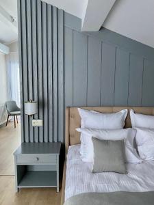 ein Schlafzimmer mit einem Bett mit einer grauen Wand in der Unterkunft Sadyba Lisova in Ternopil