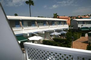 un balcón de un hotel con sombrillas y mesas en Bungalow Tauro Maspalomas, en Maspalomas