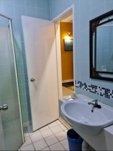 un bagno con lavandino e doccia con specchio di Villa Suria SemiD Homestay Shah Alam a Shah Alam