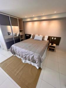 a bedroom with a large bed in a room at Tabatinga Residence Flat Pé na Areia II in Conde