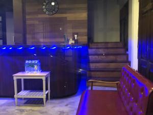 Bluefin Guesthouse في بانكوك: غرفه بطاوله ومقعد واضاءه زرقاء