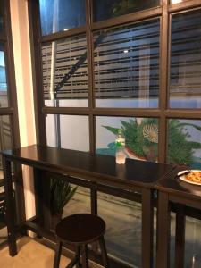 Bluefin Guesthouse في بانكوك: طاولة سوداء أمام نافذة كبيرة