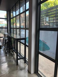 a table and chairs in a room with windows at Bluefin Guesthouse in Bangkok