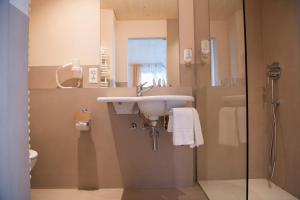 
a bathroom with a sink, toilet and shower at Hotel Silberhorn in Lauterbrunnen
