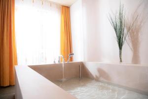 a bathroom with a tub with water in it at Hotel Silberhorn in Lauterbrunnen