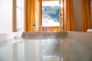 a bathroom with a sink and a window with a view at Hotel Silberhorn in Lauterbrunnen