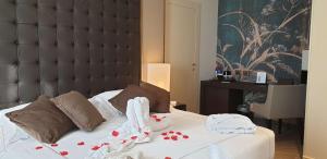 Best Western Plus Hotel Perla Del Porto في كاتانزارو ليدو: غرفة نوم عليها سرير وفوط
