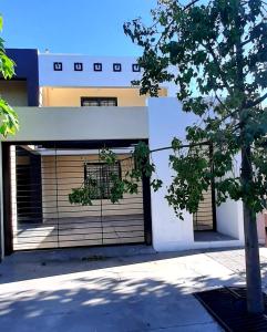 a building with two garage doors and a tree at Departamento de Huéspedes in San Martín