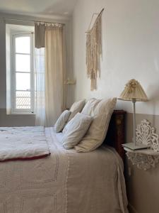 a bedroom with a bed with a lamp and a window at Le logis blanc bed&breakfast in Coursan