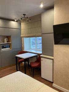 a kitchen with a table and chairs and a window at Magic Days Apartments in Chernihiv