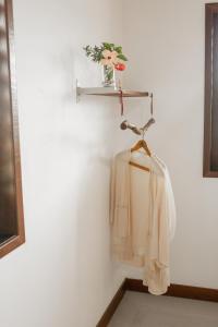una camicia bianca appesa a un muro con una mensola di Das Edelweiss a Moreré