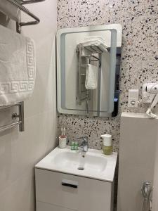 ein Bad mit einem Waschbecken und einem Spiegel in der Unterkunft Magic Days Apartments in Tschernihiw