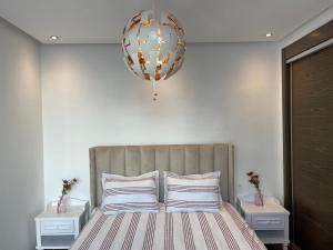 a bedroom with a bed with a large orb above it at AGADIR BAY - LUXURY APARTMENT NEAR BEACH in Agadir