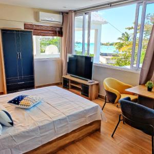 a bedroom with a bed and a flat screen tv at Grand Baie View Appart in Grand-Baie
