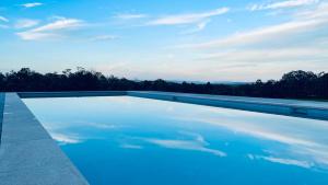 a large pool of water in front of a blue sky at Wine Country Villas in Pokolbin