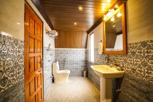 a bathroom with a sink and a toilet and a mirror at EKOSTAY - Kufri Chalet in Kūfrī
