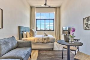 ein Wohnzimmer mit einem Bett und einem Sofa in der Unterkunft Trendy, Urban Living at The Harri w/ Views & WIFI in Kapstadt