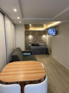 Cette chambre comprend une table, un canapé et un lit. dans l'établissement APARTAMENTOS SAN JUAN de GAZTELUGATXE, à Bermeo
