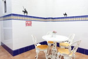 Una mesa y sillas en una habitación con paredes azules y blancas. en Best Valencia Beach Rooms-Shared Flat, en Valencia