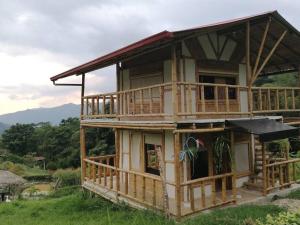 a large wooden house with a large balcony at Cabaña independiente en Granja Agroecologica in Anolaima