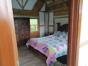 ein Schlafzimmer mit einem Bett mit einer bunten Bettdecke in der Unterkunft Cabaña independiente en Granja Agroecologica in Anolaima