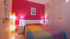 a bedroom with a rainbow bed and pink walls at Plaza Universitat in Barcelona