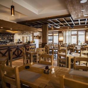 a restaurant with wooden tables and chairs and a bar at Hotel Villa Ugar Vlašić in Vlasic +29 photos