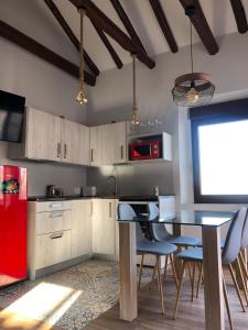 Il comprend une cuisine équipée d'une table, de chaises et d'un réfrigérateur rouge. dans l'établissement Mirador de San Juan, à Tolède
