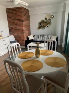 een eetkamer met een witte tafel en stoelen bij Aparthotel Claudia -self check-in in Brăila