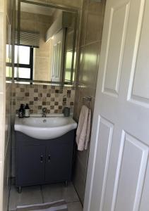 a bathroom with a sink and a mirror at 7 on Connor - Luxury Family Cottage in Bloemfontein