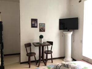 新弗里堡的住宿－Hostel Limão Doce，客厅配有桌椅和电视。