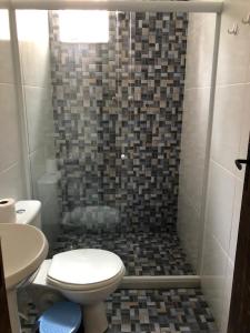 y baño con ducha, aseo y lavamanos. en Hostel Limão Doce, en Nova Friburgo