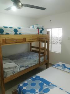 2 Etagenbetten in einem Zimmer mit Fenster in der Unterkunft Cabaña Villa Roma in Santa Marta