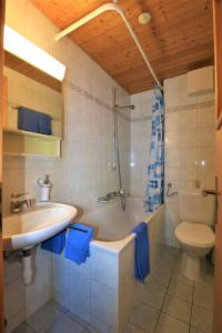 a bathroom with a tub and a sink and a toilet at Chalet Ideal Saas-Fee in Saas-Fee