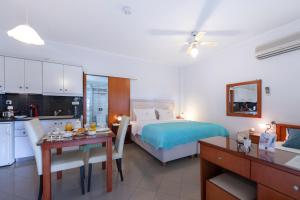 a kitchen and a bedroom with a bed and a table at Irida Beach Resort Suites in Kyparissia