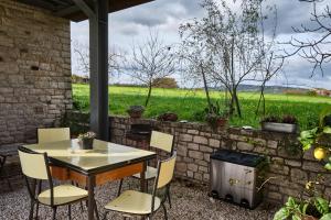 a table and chairs on a patio with a view of a field at Monolocale di Campagna - LePietreBnB in Pietrelcina