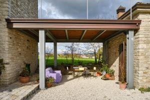 een patio met een houten pergola met een tafel en stoelen bij Monolocale di Campagna - LePietreBnB in Pietrelcina