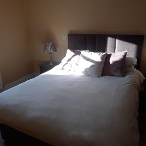 a bedroom with a large bed with white sheets and pillows at Holywood House No 2 in Hollywood
