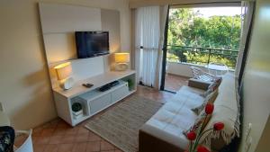 a living room with a couch and a flat screen tv at Merit Plaza Standard - Beira Mar in Florianópolis