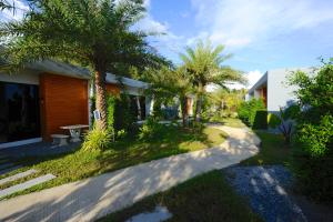 une maison avec des palmiers et une passerelle dans l'établissement Barong Resort, à Ban Phe