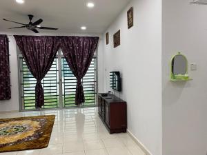 a living room with a ceiling fan and a large window at JARUM PENITI HOMESTAY PCB KOTA BHARU in Kota Bharu