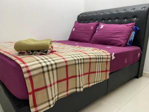 コタバルにあるJARUM PENITI HOMESTAY PCB KOTA BHARUの黒いベッド(紫色のシーツ、紫色の枕付)