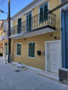 un edificio con balcón y puerta blanca en Lefkada Triola Apartments, en Lefkada