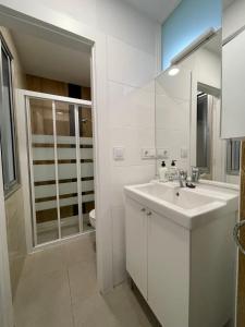 W białej łazience znajduje się umywalka i lustro. w obiekcie Apartamentos turísticos Pidal 3 VUT-09-316 w mieście Burgos