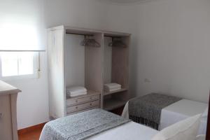um quarto com 2 camas e uma cómoda com um espelho em APARTAMENTO AROSA em Vilanova de Arousa