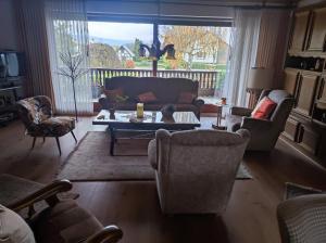 a living room with a couch and chairs and a table at Wiehenblick in Hüllhorst