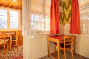 uma sala de jantar com uma mesa e uma janela em Chalet Methfessel by Arosa Holiday em Arosa
